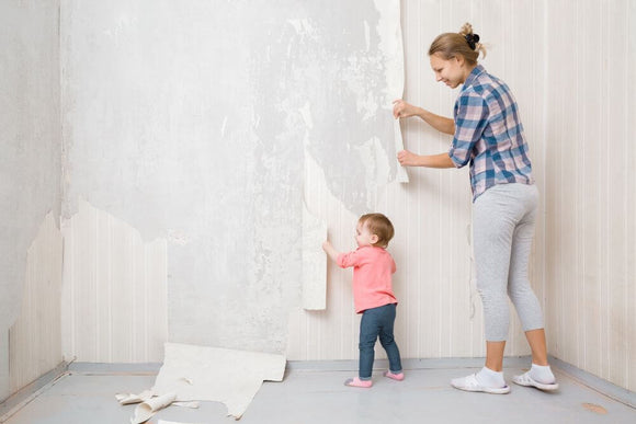 Woman removing old wallpaper in East Brookfield, MA